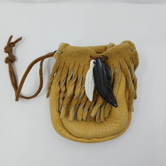 Tan leather pouch with copper beads and feath...
