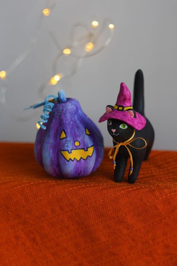 Black Halloween cat and purple pumpkin figuri...