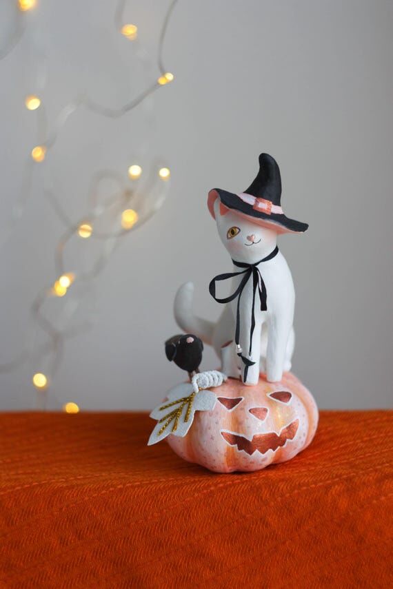 White Halloween cat figurine with pink pumpki...