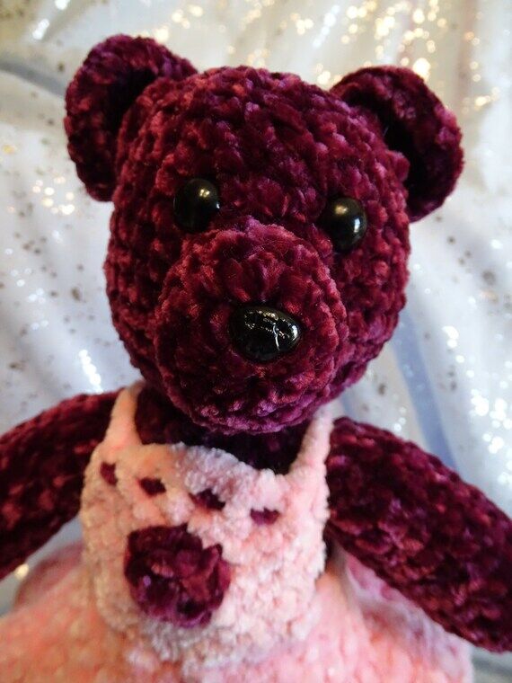Burgundy teddy bear wearing a pink dress. Ha...