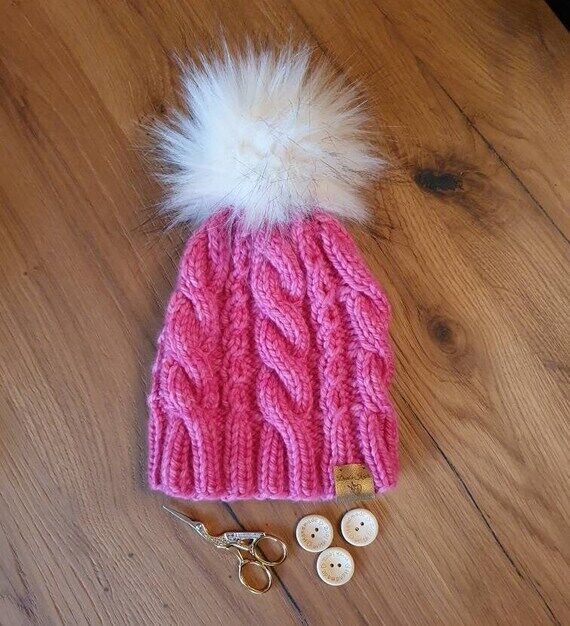 Handknitted beanie and handmade pompon. Pure ...