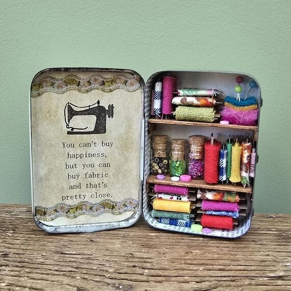 Miniature sewing room scene in a vintage tin....