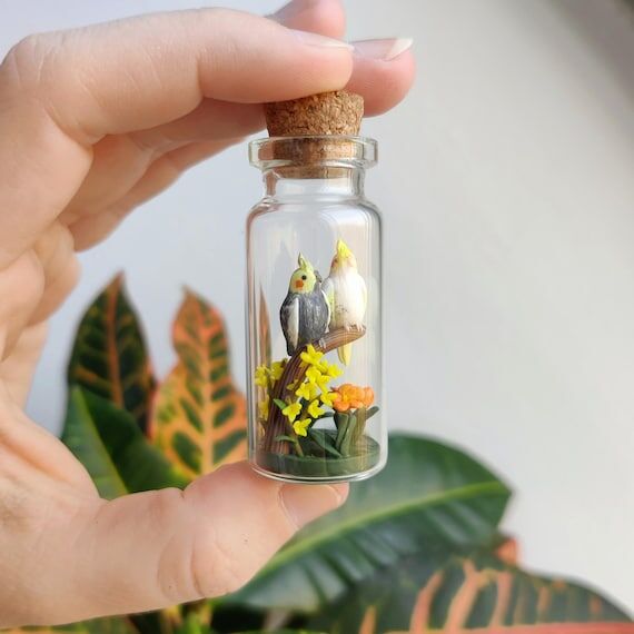 two little cockatiels surrounded by flowers i...
