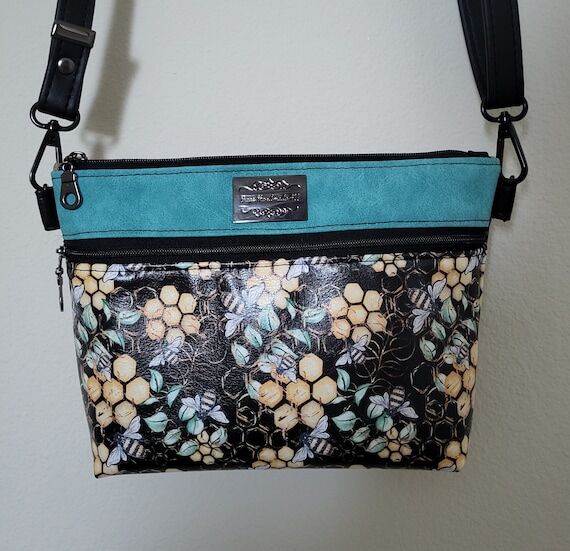 Vinyl crossbody/shoulder purse featuring busy...